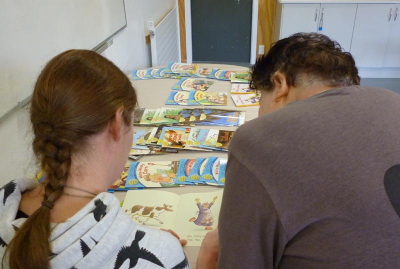 Woman and coach choosing a book to read.