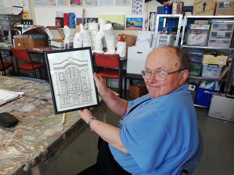 C.S. Art member Lawrence with his sketch of the building that houses C.S. Art