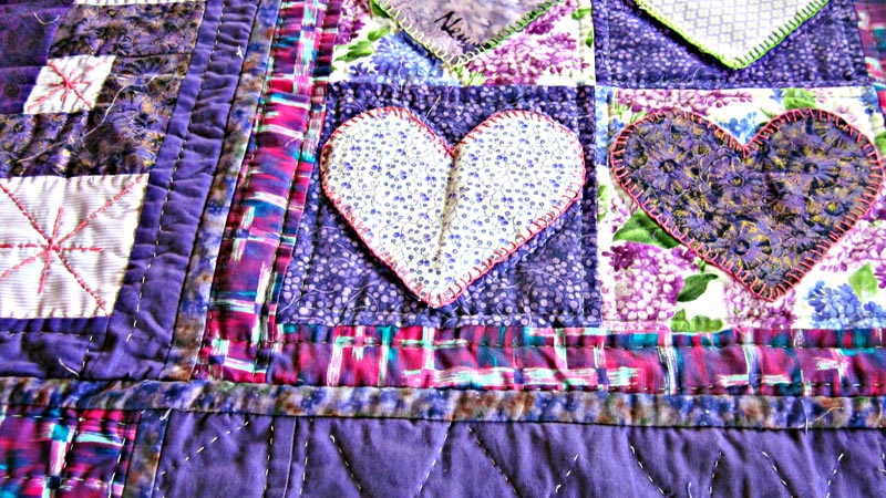 Detail of a quilt made by a prisoner at Auckland Region Women's Corrections Facility. It has a purple background with two hearts