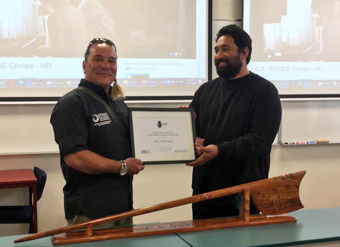 Chris Ulutupu, Arts in Corrections Advisor, Arts Access Aotearoa, presents a carving made by a carver at Hawkes Bay Regional Prison to Rue-Jade Morgan at an Arts in Corrections South Island Network meeting in Dunedin