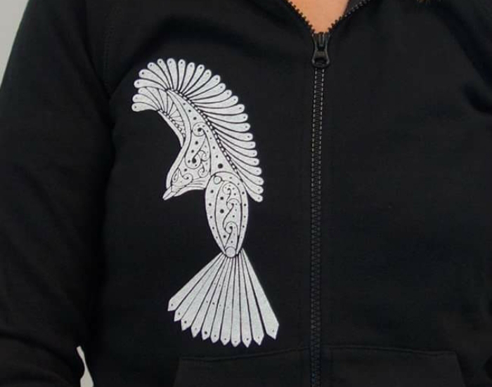 A white fantail screenprinted on a black hoodie by the Navigate Initiative