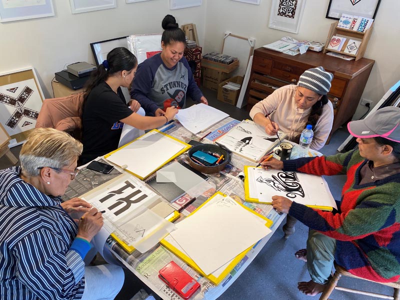 Artists from Artists in the Making refining their designs for screenprinting at Pete Sephton art studio, Coromandel