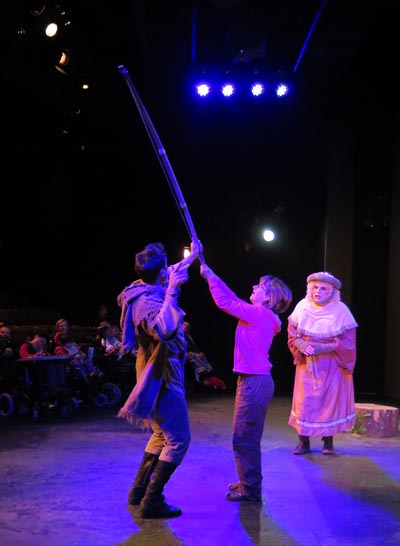 Liz on stage with Robin Hood's bow and arrows