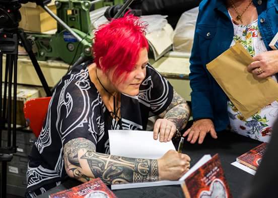 Anita Mary signing opies of her book at the launch