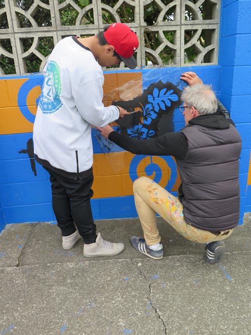Chris Barrand works with a student on a mural in Cannons Creek