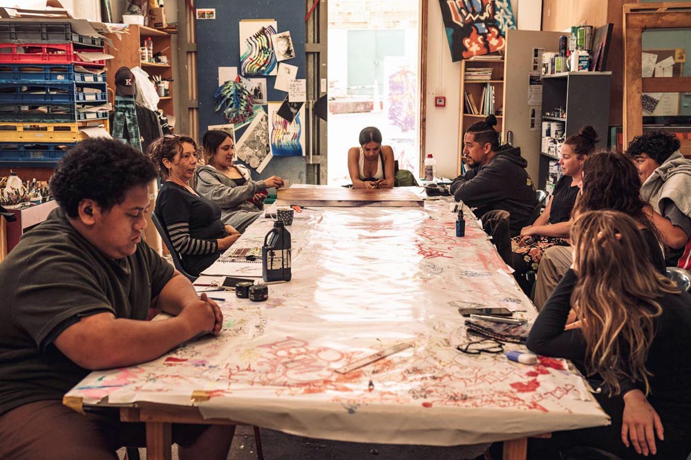 Rangatahi and tutors in discussion around a large table