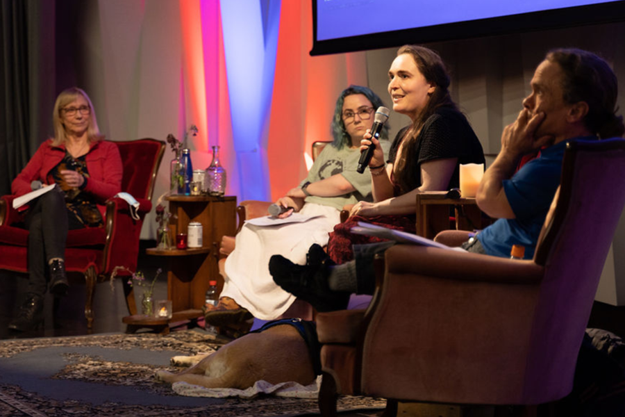 A panel of people sit on arm chairs on a stage at Verb Festival.