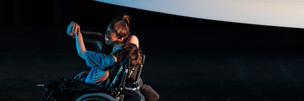 two dancers, one in a wheelchair dancing beneath a large piece of white fabric