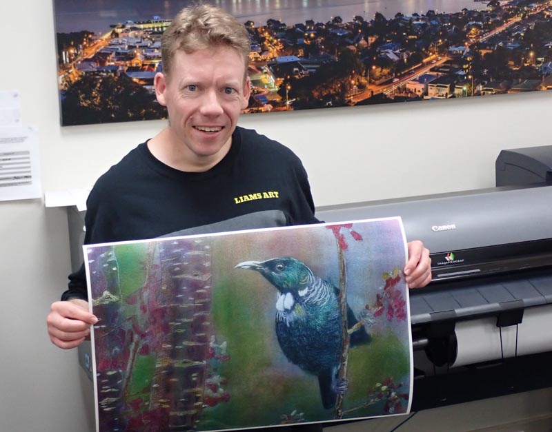 Toi Ora artist Liam O'Halloran with his painting of a tui
